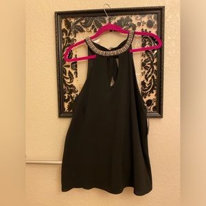 Black halter top with embellishments around necklace. Tie keyhole back. Sz Med